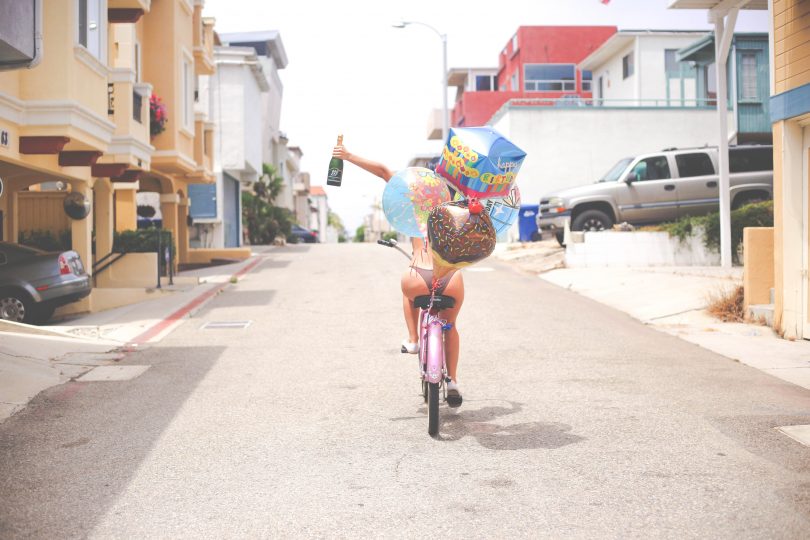 Девушка с шариками на велосипеде в день рождения
